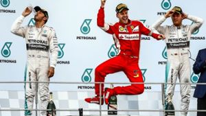 Sebastian Vettel feiert seinen ersten Grand-Prix-Sieg mit Ferrari – die Silberpfeil-Piloten Lewis Hamilton (li.) und Nico Rosberg beschäftigen sich mit anderen Dingen Foto: dpa