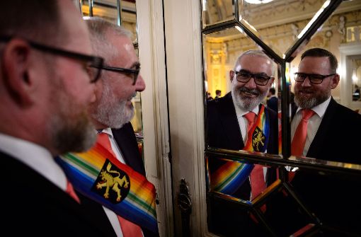 Wolfgang Erichson (Mitte), Bürgermeister für Integration in Heidelberg, und sein Ehemann Bertold Quast nach ihrer Hochzeitszeremonie, bei der 44 gleichgeschlechtliche Paare getraut wurden. Foto: dpa