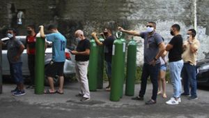 Familienmitglieder von Covid-19-Patienten stehen an, um Sauerstoffflaschen auffüllen zu lassen. In Manaus herrscht derzeit akuter Mangel von Sauerstoff für Kranke. Foto: dpa/Edmar Barros