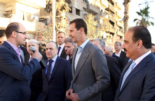Präsident Baschar al-Assad (Mitte) im Gespräch mit der Presse: Er ruft die Syrer zur Aussöhnung auf. Foto: AFP