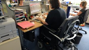 Eine im Rollstuhl sitzende Frau arbeitet als Telefonserviceberater in einem Call-Center.  Schwerbehinderte konnten vom anhaltend positiven Trend auf dem Arbeitsmarkt bisher nicht profitieren. Foto: dpa