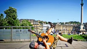 Rücklings mit zappelnden Beinen liegt Straßenmusiker Kieran Hilbert  bei „Highway to Hell“ auf dem Schlossplatz-Boden. Foto: Lichtgut/Achim ZweygarthLichtgut/Achim Zweygarth
