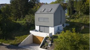 Umgeben von Bäumen  schmiegt sich  das schmale, dunkelgraue Haus von Architekt Christian Fischer ins Hanggrundstück in Stuttgart-Feuerbach. Foto: Aras Gökten/STUDIOFISCHER