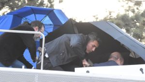 Der Istanbuler Oberbürgermeister Ekrem Imamoglu flieht  im Steinhagel von der Bühne. Foto: IMAGO/Depo Photos/IMAGO/Cem Bakirci