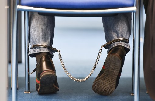 Mit Fußfesseln sitzt einer der Angeklagten im Verhandlungssaal des Landgerichts Mannheim. Foto: dpa
