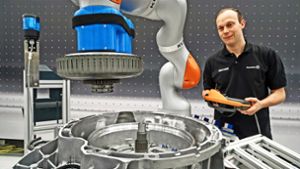 Dieser  Roboter hilft bei der  Montage   von Getrieben, wie bei dieser Präsentation  in der Tec-Fabrik von Daimler gezeigt wird. Foto: Daimler