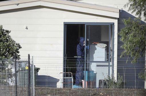 Ein Mitarbeiter der Spurensicherung untersucht den Tatort des mutmaßlichen Familiendramas. Foto: AP
