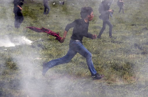An der griechisch-mazedonischen Grenze feuern Sicherheitskräfte wieder mit Tränengas auf Flüchtlinge. Foto: AP