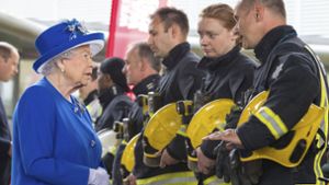 Queen Elisabeth II. trifft während eines Besuchs des Westway Sports Centre – wo Verunglückte vorübergehend untergebracht werden – auf Feuerwehrleute. Foto: Pool PA