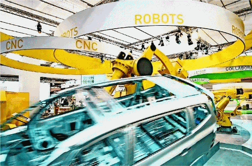 Ein Roboter bewegt auf der Hannover Messe eine Autokarosserie durch die Luft: Rund um eine Messe arbeiten viele Menschen mit den unterschiedlichsten Berufen. Foto: dpa
