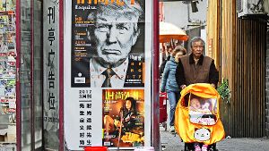 An einem Zeitungsladen in Shanghai hängt ein Werbeplakat für eine Zeitschrift – deren Titelblatt die finstere Miene Trumps zeigt. Foto: AP