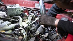 Ein Mechaniker arbeitet in  seiner Werkstatt  an einem Auto. Foto: dpa/Fabian Sommer