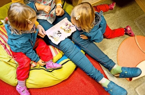 Eine Erzieherin liest Kindern in einer Kita aus einem Buch vor. Foto: dpa