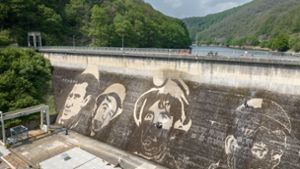 Das Kunstwerk auf der Staumauer zeigt Arbeiter-Porträts. Foto: Kärcher/David Franck