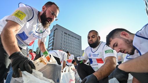Die Mitglieder des französischen Spogomi-Teams mit ihren gesammelten Müllbeuteln. Foto: AFP/Richard A. Brooks
