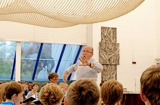 Martin Dücker  leitet die Mädchenkantorei und dirigiert den Chor in großer Besetzung zusammen mit den Stuttgarter Hymnus-Chorknaben im Probenraum. Foto: Sybille Neth