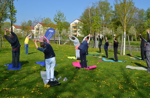 Artur Lorenz (im gelben T-Shirt) leitet die Yoga-Einheit im Bürgergarten Fasanenhof an. Foto: Sandra Hintermayr
