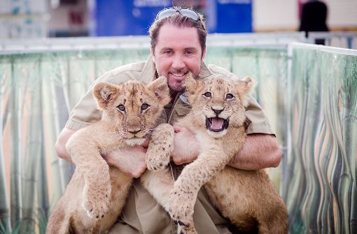 Dompteur Martin Lacey mit den beiden Löwenbabys Sarah und Benjamin. Foto: dpa
