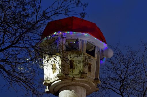 Eine rote Weihnachtsmütze ist  in Berlin auf dem Dach eines ehemaligen DDR-Grenzwachturms am Potsdamer Platz zu sehen. Foto: dpa