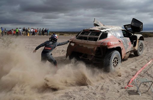 Peugeot-Fahrer Cyril Despres schiebt sein Auto an. Die Rallye Dakar ist brandgefhrlich  und sie produziert spektakulre Bilder. Eine Auswahl der Rallye 2016 zeigen wir in der folgenden Fotostrecke. Foto: AP