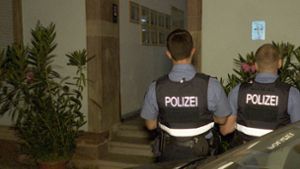 Polizeibeamte stehen vor dem Hauseingang der tatverdächtigen Frau. Foto: dpa/Thorsten Kremers