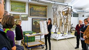 Die Museumsleiterin Nina Hofmann  zeigt eine Preistafel –  ein Exponat aus dem Depot des Museums. Foto: factum/Granville