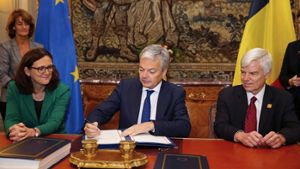 Der belgische Außenminister Didier Reynders unterzeichnet das Handelsabkommen Ceta Foto: Belga