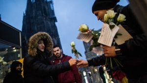 Versuch der Wiedergutmachung: Ein Mitglied eines deutsch-tunesischen Vereins verteilt in Köln Blumen an Passantinnen. Foto: dpa