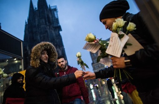 Versuch der Wiedergutmachung: Ein Mitglied eines deutsch-tunesischen Vereins verteilt in Köln Blumen an Passantinnen. Foto: dpa