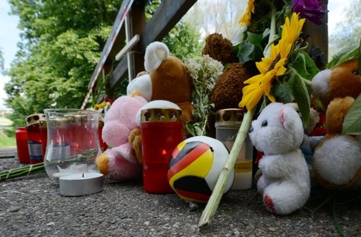 Kuscheltiere, Grablichter, ein Fußball und Blumen liegen in Freiburg am Fundort des getöten achtjährigen Armani. (Archivfoto) Foto: dpa