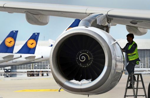 Ein Lufthansa-Techniker arbeitet an einem parkenden Flugzeug: Erst 2023 dürfte die Luftfahrt weltweit wieder im Gleichgewicht sein. Foto: AFP/Christof  Stache