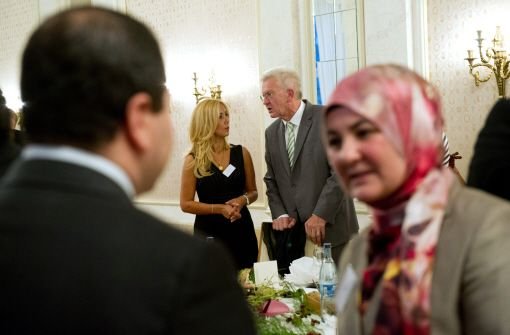 Baden-Württembergs Ministerpräsident Winfried Kretschmann im Gespräch mit der muslimischen Unternehmerin Mehtap Camcaz (im Hintergrund) Foto: dpa