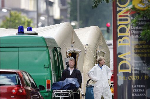 Mafiamord in Duisburg: Ein Bestatter schiebt 2007  eine Trage mit einer verdeckten Leiche von einem Tatort. Foto: dpa