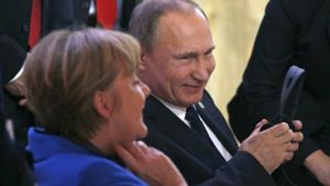 Auf dem Klimagipfel in Paris an der Seite von Kanzlerin Merkel gibt sich Putin locker. Doch im Konflikt mit der Türkei bleibt der russische Präsident hart. Foto: dpa