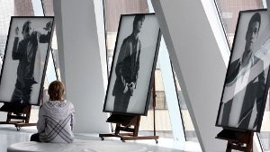 Ein Junge betrachtet im Juni 2008 im Mercedes-Benz Museum in Stuttgart drei Fotos der Bildserie Männer zeigen Strenesse. Das Modeunternehmen ist ins Straucheln gekommen. Foto: dpa