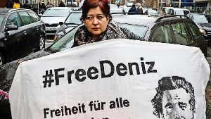 Deniz Yücels Schwester Ilkay  hält   in Frankfurt am Main zu Beginn eines Autokorsos ein Plakat mit dem Konterfei ihres Bruders in den Händen. Foto: dpa