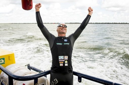 Jubelnd reißt er die Arme in die Luft: Rheinschwimmer Andreas Fath ist am Ziel in Holland angekommen. Foto: dpa