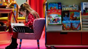 Versunken in der eigenen Fantasie: ein Mädchen liest bei der Buchmesse Foto: dpa-Zentralbild