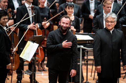 Kirill Petrenko (Mitte) neben dem Bass-Solisten Kwangchul Youn und Musikern der Berliner Philharmoniker nach seinem Antrittskonzert Foto: dpa