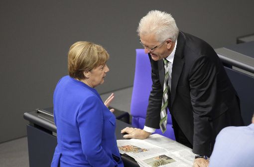 Winfried Kretschmann unterhält sich am Freitag im Bundestag mit Kanzlerin Merkel. Foto: AP