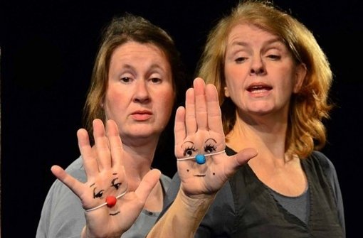 Annette Scheibler und Sigrun Kilger  spielen „Traumkreuzung“ auf ihren Handflächen. Foto: Theater