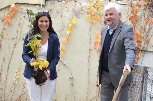 Die Schulleiterin Corinna Emeling und der Regierungspräsident Wolfgang Reimer pflanzen einen Brombeerstrauch für den Schulgarten der Fasanenhofschule. Foto: Sandra Hintermayr