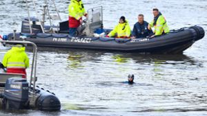 Castor-Transport-Gegner schwimmen neben Polizeibooten im Neckar. Foto: dpa