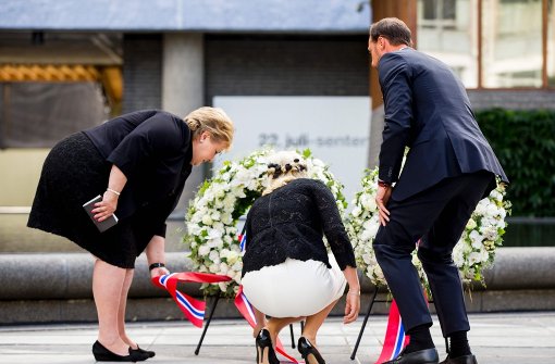 Zusammen mit der Ministerpräsidentin Erna Solberg (links), legen Kronprinzessin Mette-Marit (Mitte) und ihr Mann, Prinz Haakon, im Gedenken an die Opfer Kränze nieder. Foto: AFP