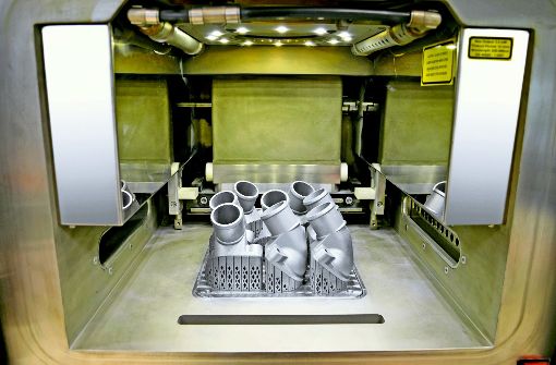 Ersatzteile für Mercedes-Benz Lkw aus dem 3-D-Drucker: Der Blick in den Innenraum des 3-D-Druckers zeigt gedruckte Thermostatabdeckungen, die noch mit der Bauplattform verbunden sind. Foto: Daimler AG