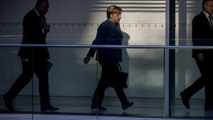 Bundeskanzlerin Angela Merkel (CDU) geht in Begleitung von einem Fraktionsmitarbeiter (l) und einem Sicherheitsbeamten (r) zu weiteren Sondierungsgesprächen. Foto: dpa