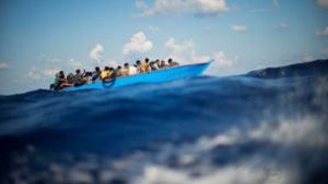 Menschen, die nach Europa wollen, sitzen in einem Holzboot im Mittelmeer. Symbolbild Foto: Francisco Seco/AP/dpa
