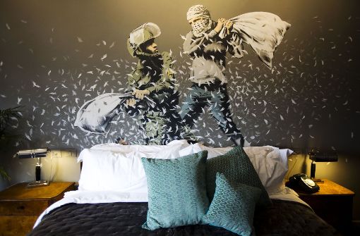 Ein Wandbild des britischen Street-Art Künstlers Banksy mit einem israelischen Soldaten und einem Palästinenser bei einer Kissenschlacht ziert ein Zimmer des „The Walled Off Hotel“ in Bethlehem. Foto: AP