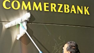 Ein Gebäudereiniger poliert in Frankfurt das Firmenschild der Commerzbank – mit dem Strafzins macht die Bank Großanlegern wenig Freude Foto: dpa