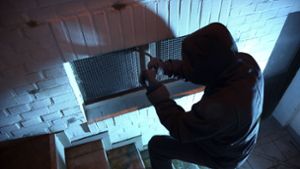 Ein Einbrecher bricht mit einem Brecheisen ein Kellerfenster in einem Kellerzugang auf (Symbolfoto). Foto: imago stock&people/imago stock&people